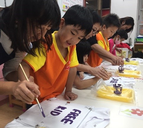 企鵝班的志工家長們，和小朋友一起繪製T恤，大小朋友們都相當享受過程。