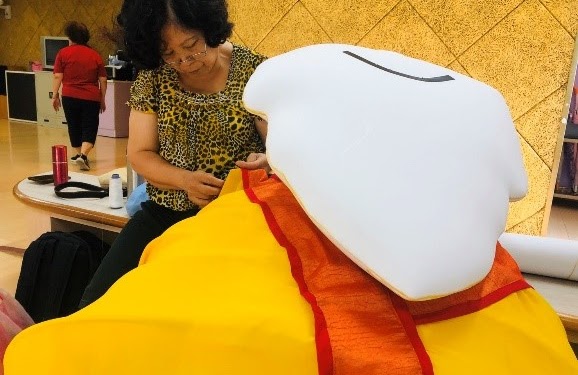 將大偶立起之後，調整土地公大偶的衣服。